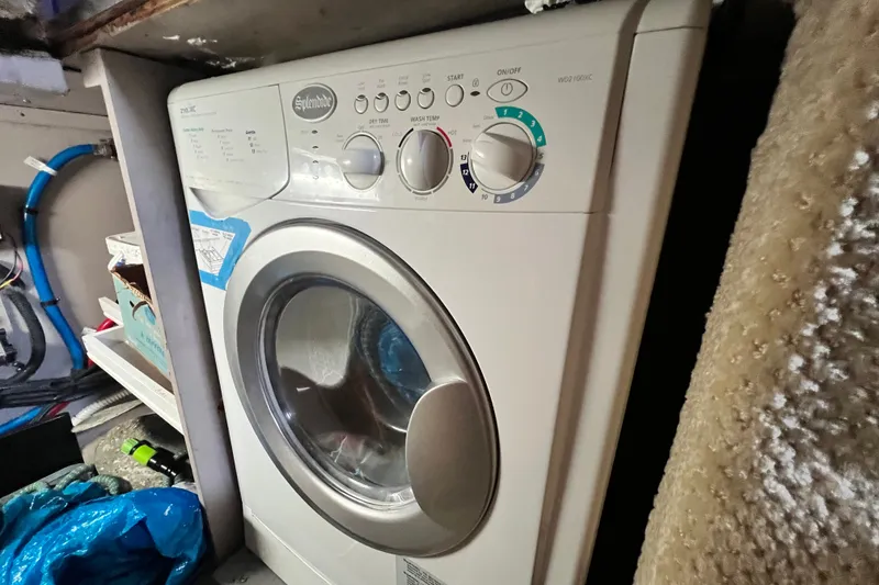Slide: The Image of Laundry area inside a 2003 Sea Ray 480 Motor Yacht, featuring a compact washing machine. - 54
