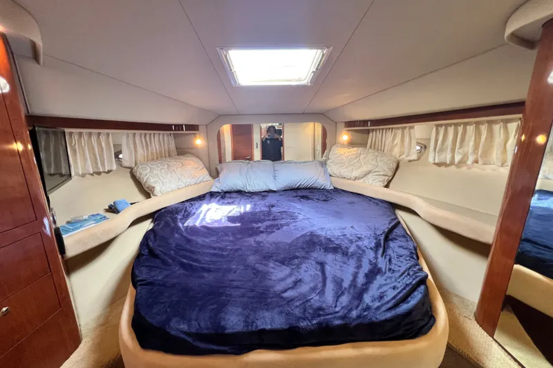 Slide: The Image of Luxurious 2003 Sea Ray 480 Motor Yacht bedroom with plush bedding and elegant wood accents. - 106