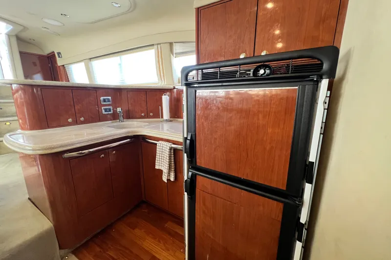 Slide: The Image of Luxurious kitchen interior of 2003 Sea Ray 480 Motor Yacht with wood cabinetry and modern appliances. - 126
