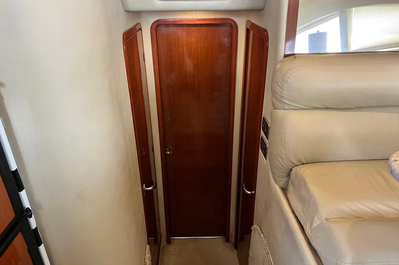 Slide: The Image of Interior hallway of 2003 Sea Ray 480 Motor Yacht with wooden doors and beige seating. - 100