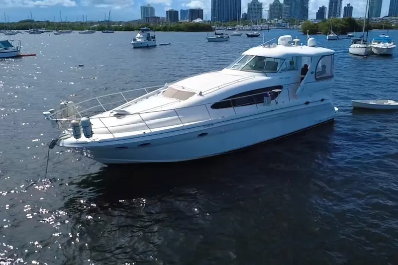 Slide: The Image of 2003 Sea Ray 480 Motor Yacht on calm waters with city skyline in background. - 11