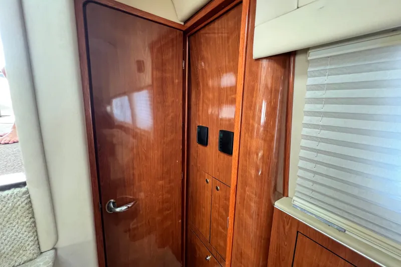 Slide: The Image of Interior of 2003 Sea Ray 480 Motor Yacht with wooden cabinetry and blinds. - 147