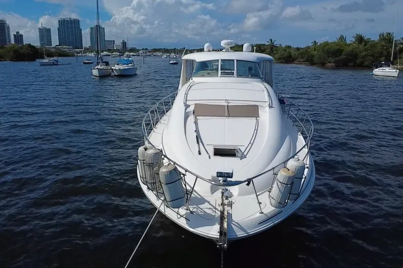 Slide: The Image of 2003 Sea Ray 480 Motor Yacht anchored in a scenic harbor with city skyline. - 2