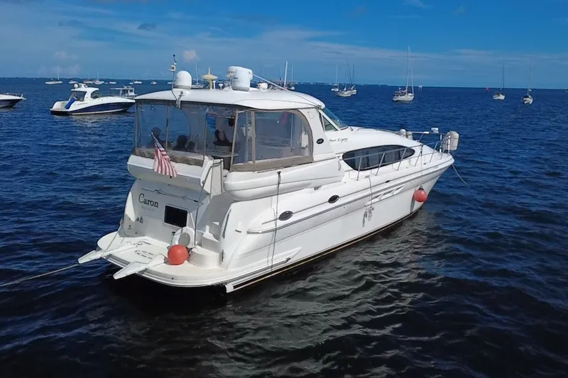 Slide: The Image of 2003 Sea Ray 480 Motor Yacht on calm blue waters, surrounded by other boats. - 6