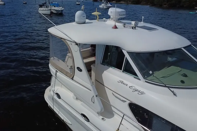 Slide: The Image of 2003 Sea Ray 480 Motor Yacht on calm water, surrounded by other boats. - 204