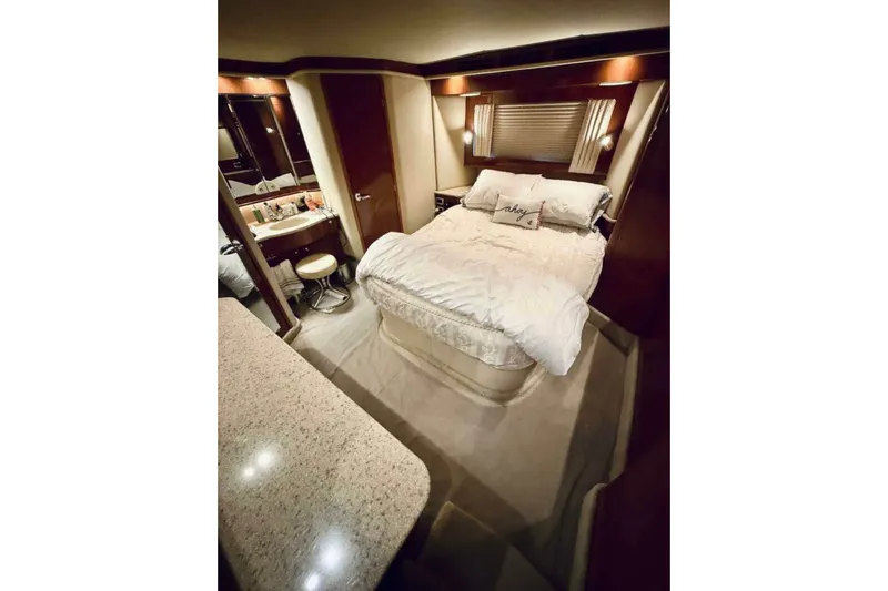 Slide: The Image of Luxurious bedroom interior of 2003 Sea Ray 480 Motor Yacht with elegant bedding and vanity area. - 16