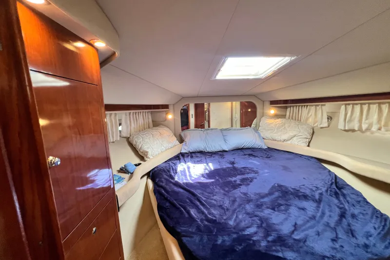 Slide: The Image of Luxurious 2003 Sea Ray 480 Motor Yacht bedroom with plush bedding and elegant wood finishes. - 124