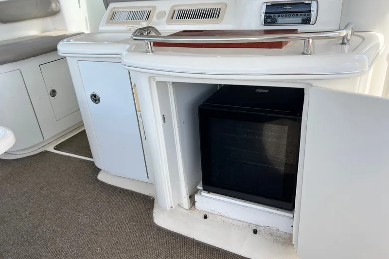Slide: The Image of 2003 Sea Ray 480 Motor Yacht interior with open cabinet and built-in mini fridge. - 178