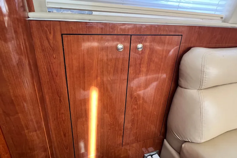 Slide: The Image of Interior of 2003 Sea Ray 480 Motor Yacht with wood paneling and beige seating. - 150