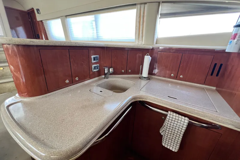 Slide: The Image of 2003 Sea Ray 480 Motor Yacht kitchen with wooden cabinets and countertop. - 128