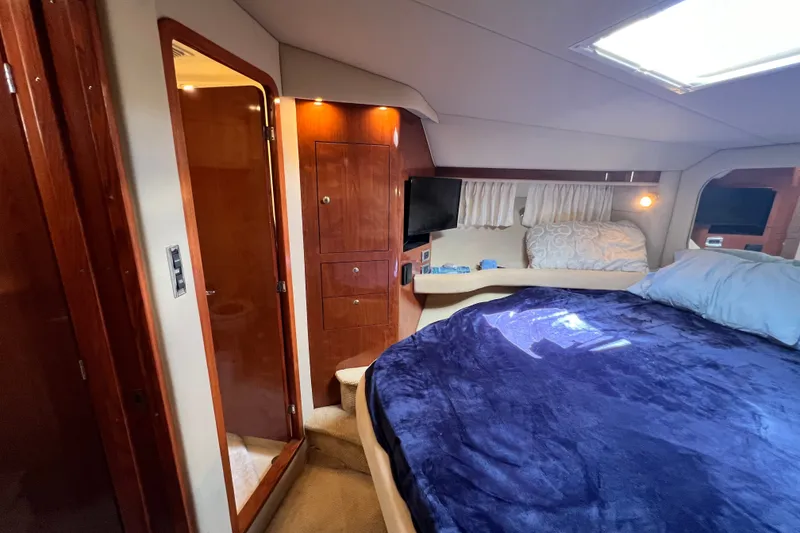 Slide: The Image of Luxurious 2003 Sea Ray 480 Motor Yacht bedroom with plush bedding and elegant wood finishes. - 108