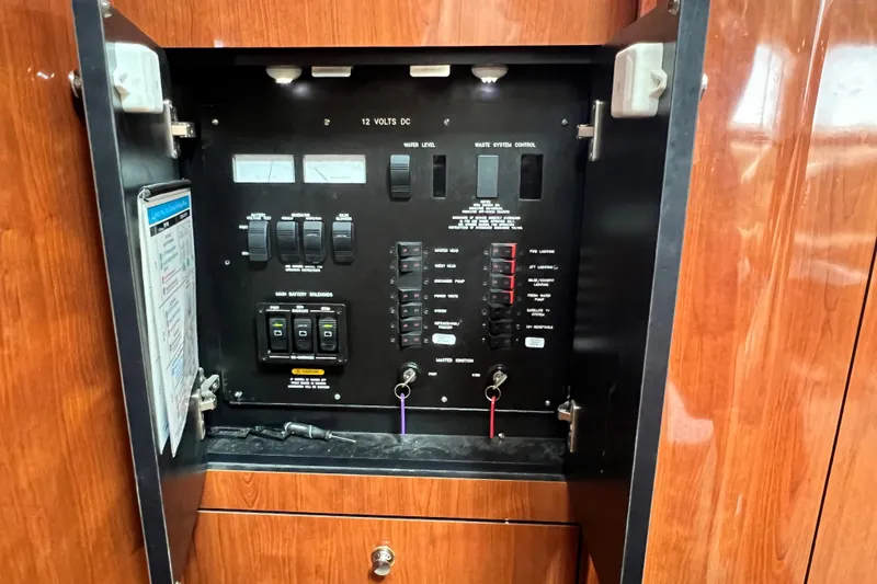 Slide: The Image of Electrical control panel inside 2003 Sea Ray 480 Motor Yacht, featuring switches and indicators. - 148