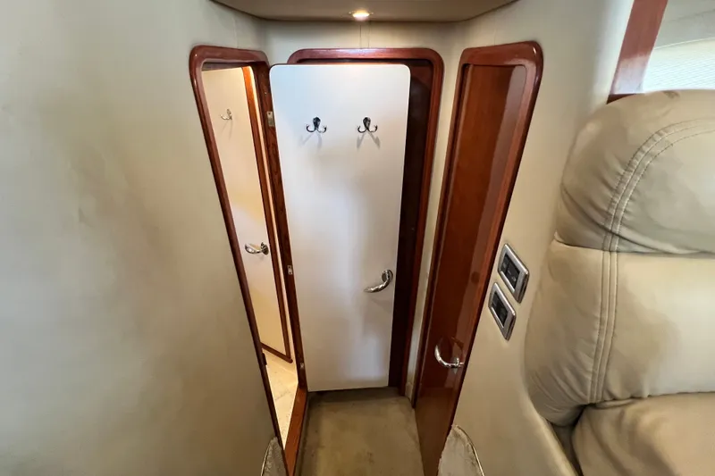 Slide: The Image of Interior hallway of 2003 Sea Ray 480 Motor Yacht with wooden doors and hooks. - 116