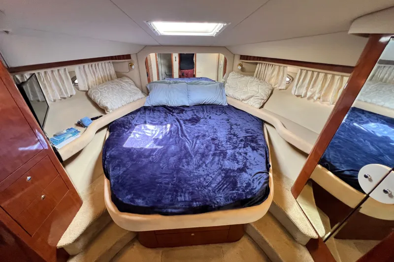 Slide: The Image of Luxurious 2003 Sea Ray 480 Motor Yacht bedroom with plush bedding and elegant wood accents. - 103