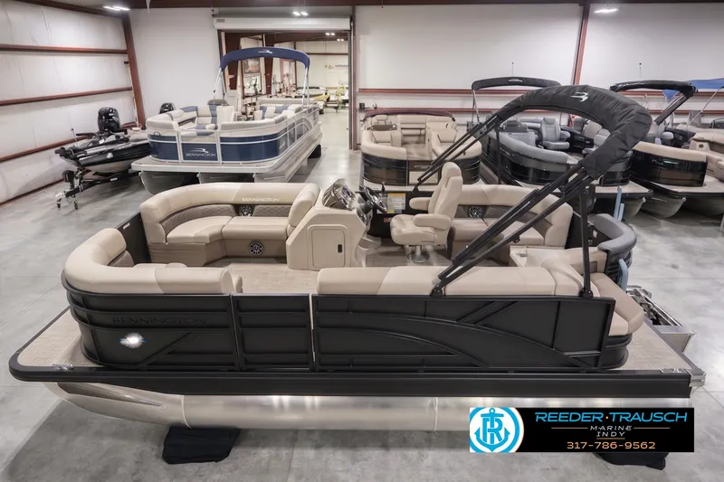 The Image of 2027 Bennington 168 SLJ pontoon boat in showroom, featuring beige seating and black accents. - 0