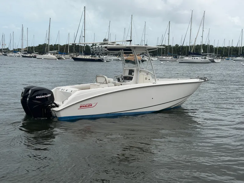 Slide: The Image of A 2006 Boston Whaler 240 Outrage on the water, surrounded by other boats in the harbor. - 5