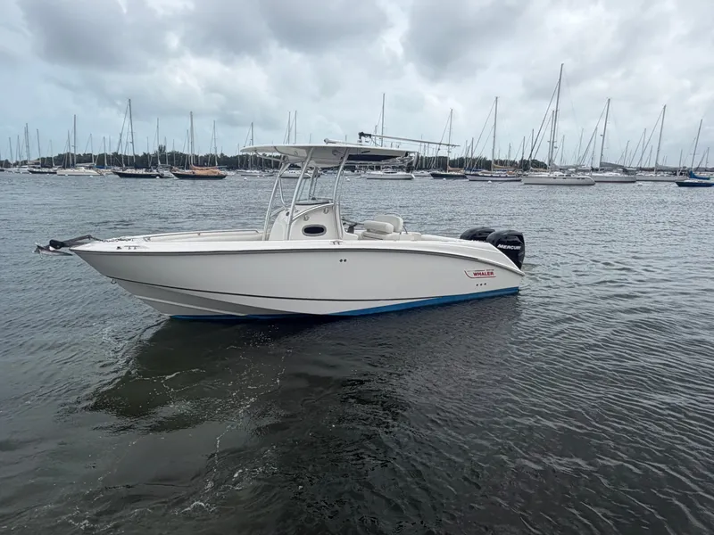 Slide: The Image of A 2006 Boston Whaler 240 Outrage on the water, surrounded by sailboats in the background. - 3