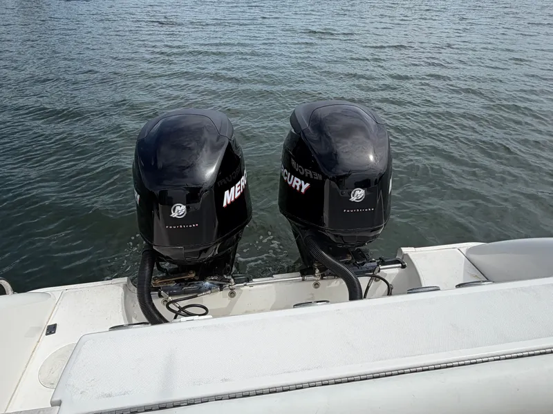 Slide: The Image of Two Mercury outboard engines on a 2006 Boston Whaler 240 Outrage on calm water. - 8