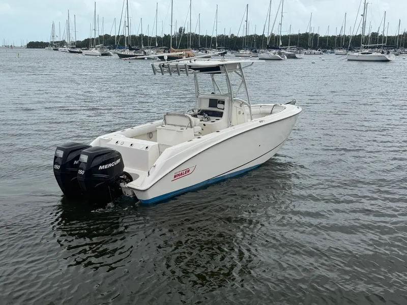 Slide: The Image of A 2006 Boston Whaler 240 Outrage on the water, featuring twin Mercury engines and a T-top. - 1