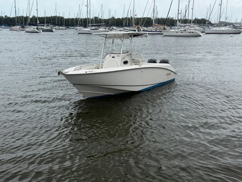 Slide: The Image of A 2006 Boston Whaler 240 Outrage on calm water, surrounded by other boats. - 2