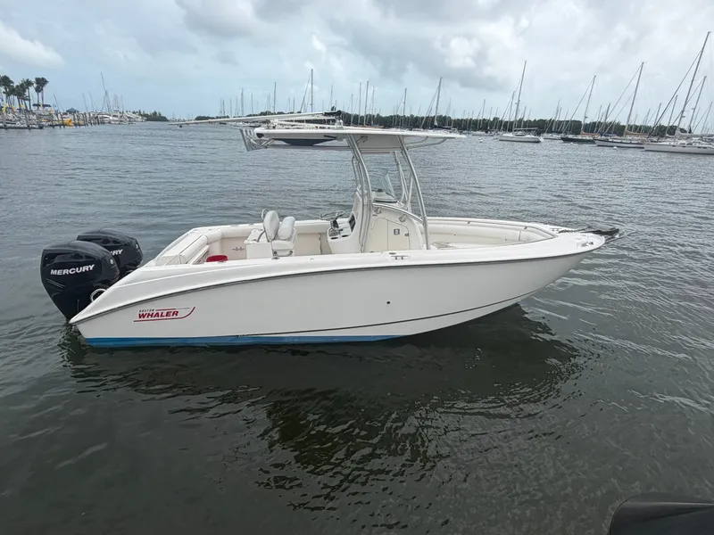 Slide: The Image of A 2006 Boston Whaler 240 Outrage on the water, surrounded by sailboats in the background. - 6