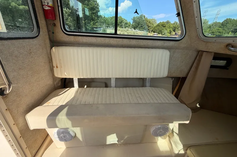 Slide: The Image of Interior of 2003 Parker 2120 Sport Cabin boat with cushioned seating and windows. - 10