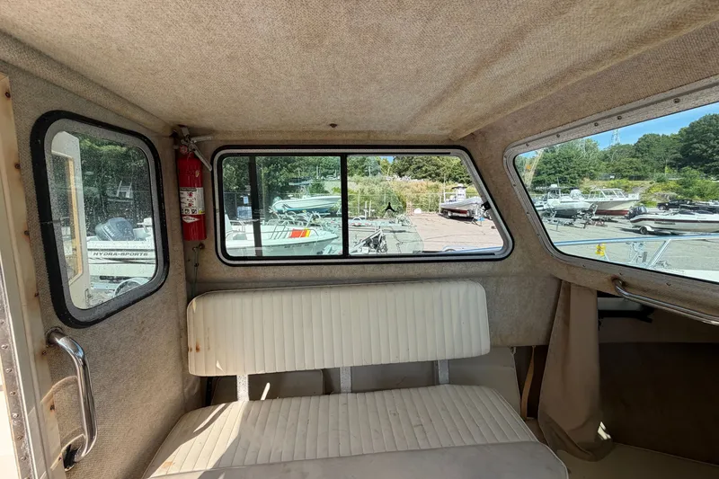Slide: The Image of Interior of a 2003 Parker 2120 Sport Cabin boat with seating and windows. - 22