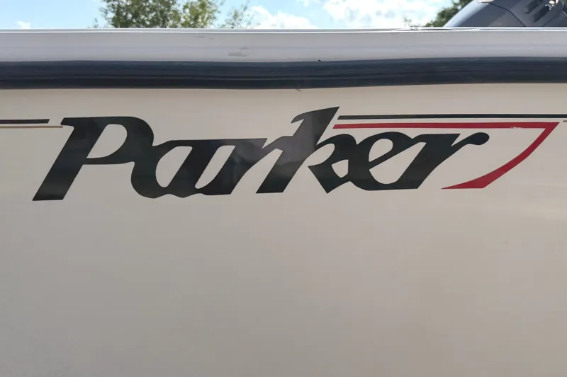 Slide: The Image of 2003 Parker 2120 Sport Cabin boat with distinctive logo on the side. - 2