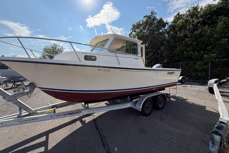 Slide: The Image of 2003 Parker 2120 Sport Cabin boat on trailer under sunny sky. - 3