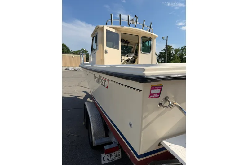 Slide: The Image of 2003 Parker 2120 Sport Cabin boat on trailer, parked outdoors under clear sky. - 4