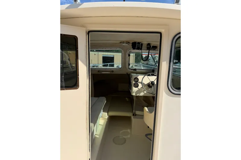 Slide: The Image of 2003 Parker 2120 Sport Cabin interior with steering wheel and seating area. - 12