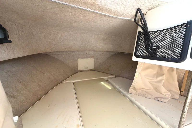 Slide: The Image of Interior of the 2003 Parker 2120 Sport Cabin with cushioned seating and storage space. - 7