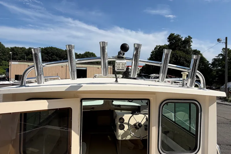 Slide: The Image of The image shows the rear of a 2003 Parker 2120 Sport Cabin with fishing rod holders. - 11