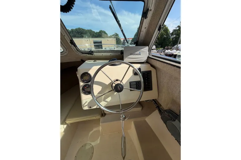Slide: The Image of Interior view of 2003 Parker 2120 Sport Cabin boat with steering wheel and Garmin device. - 17