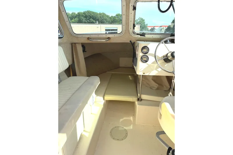 Slide: The Image of Interior of the 2003 Parker 2120 Sport Cabin with bench seating and helm. - 6