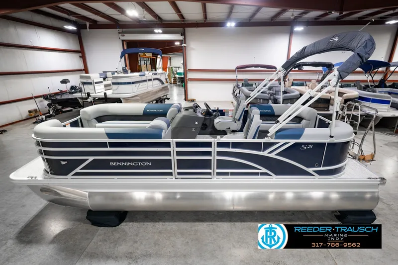 The Image of 2027 Bennington 21 SSR pontoon boat in showroom, featuring sleek design and modern seating. - 0