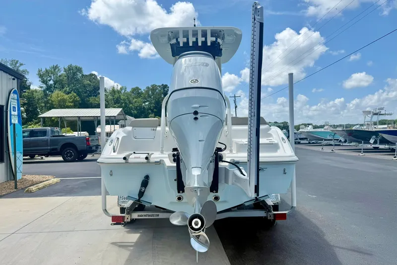 Slide: The Image of 2025 Key West 219 FS boat with outboard motor on trailer, parked outdoors. - 2
