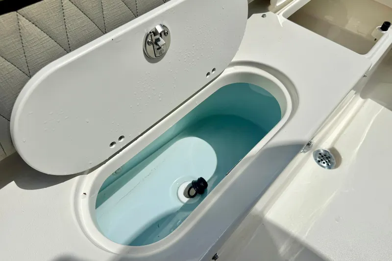 Slide: The Image of Livewell compartment on a 2025 Key West 219 FS boat, featuring a secure latch. - 31
