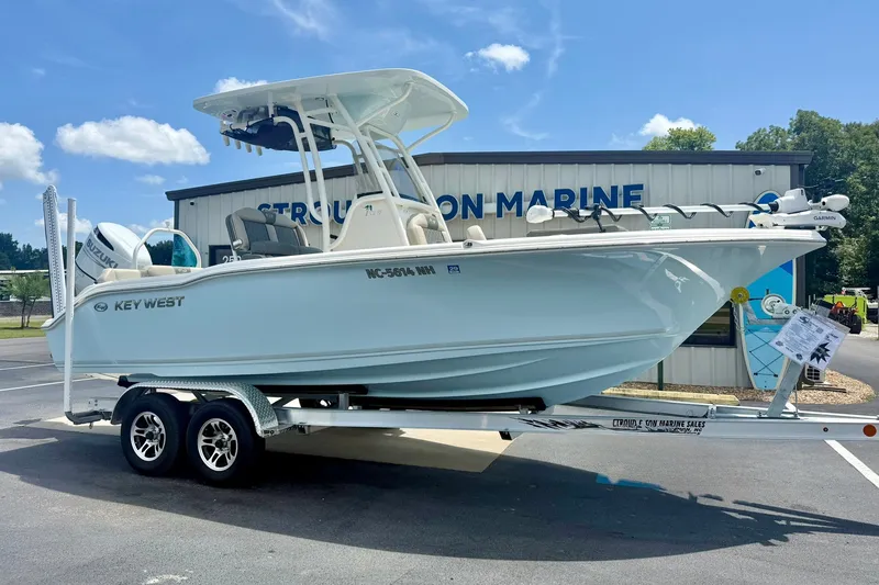 Slide: The Image of 2025 Key West 219 FS boat on trailer at dealership, sunny day. - 6