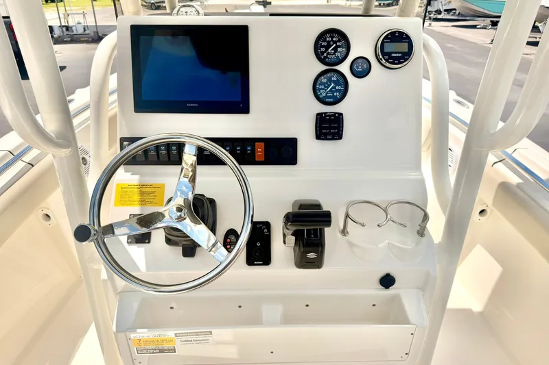 Slide: The Image of 2025 Key West 219 FS boat dashboard with steering wheel, gauges, and navigation screen. - 3
