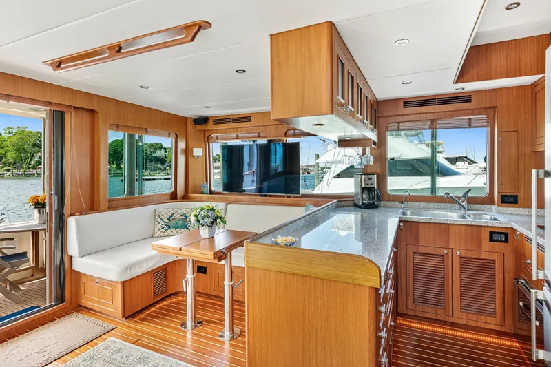 Slide: The Image of Luxurious interior of 2017 North Pacific 49 Pilothouse yacht with modern kitchen and seating area. - 14