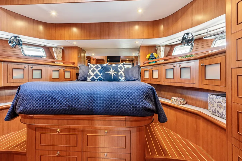 Slide: The Image of Luxurious 2017 North Pacific 49 Pilothouse yacht bedroom with elegant wood finish and blue bedding. - 23
