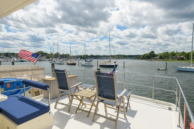 Slide: The Image of Deck view of 2017 North Pacific 49 Pilothouse yacht overlooking marina with sailboats. - 69