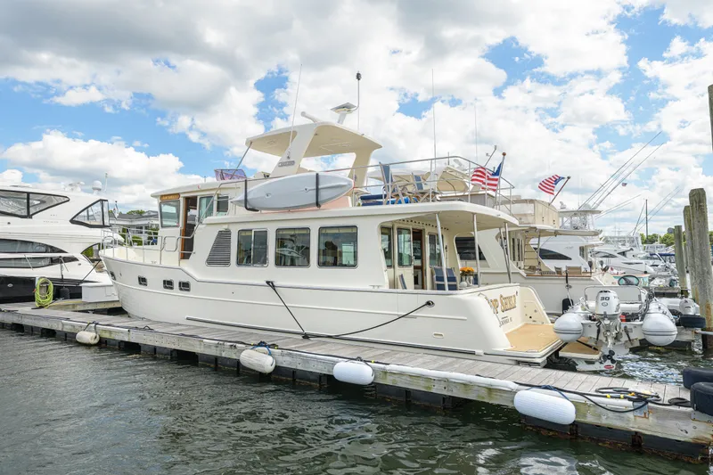 Slide: The Image of 2017 North Pacific 49 Pilothouse yacht docked at marina under cloudy sky. - 43