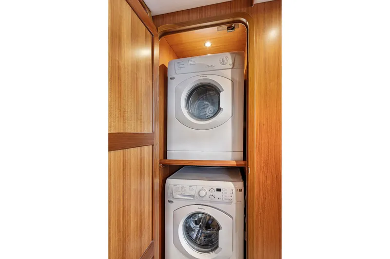 Slide: The Image of Stacked washer and dryer in 2017 North Pacific 49 Pilothouse yacht's wooden interior. - 21