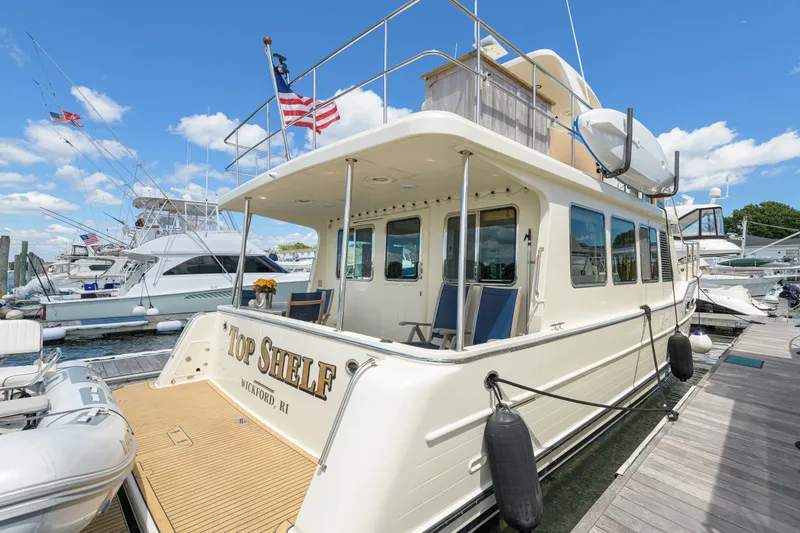 Slide: The Image of 2017 North Pacific 49 Pilothouse yacht docked, featuring spacious deck and elegant design. - 49