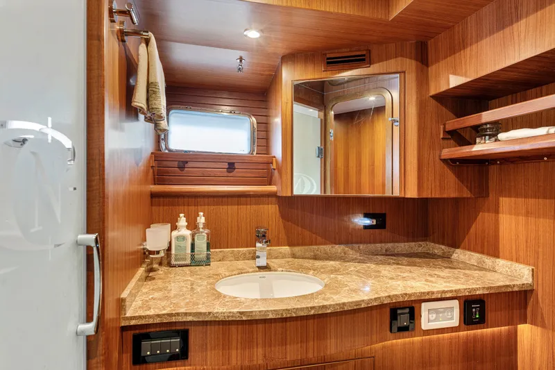 Slide: The Image of Luxurious bathroom in 2017 North Pacific 49 Pilothouse yacht with wood finish and marble countertop. - 19