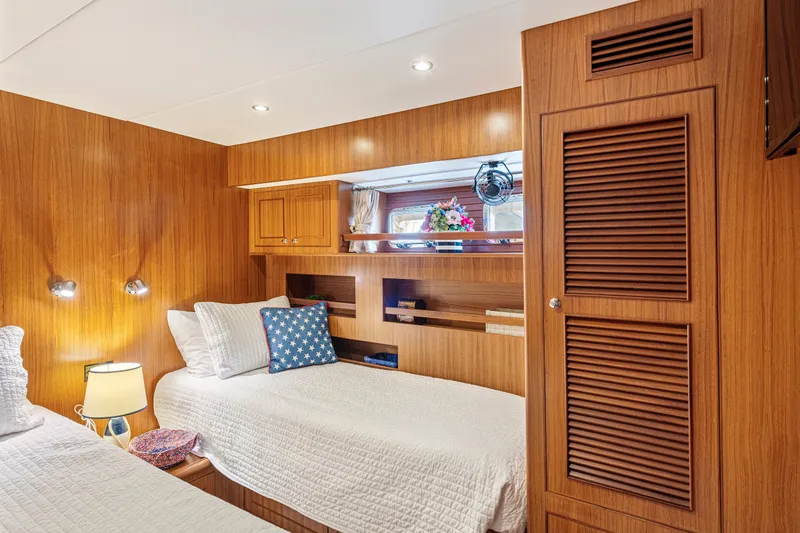 Slide: The Image of Luxurious 2017 North Pacific 49 Pilothouse cabin with twin beds and elegant wood paneling. - 17