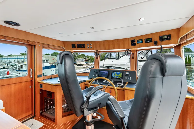Slide: The Image of Pilothouse interior of 2017 North Pacific 49, featuring navigation equipment and leather seating. - 31