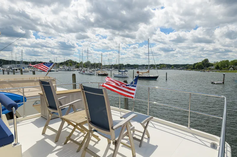 Slide: The Image of Deck view from 2017 North Pacific 49 Pilothouse yacht overlooking marina with American flags. - 68